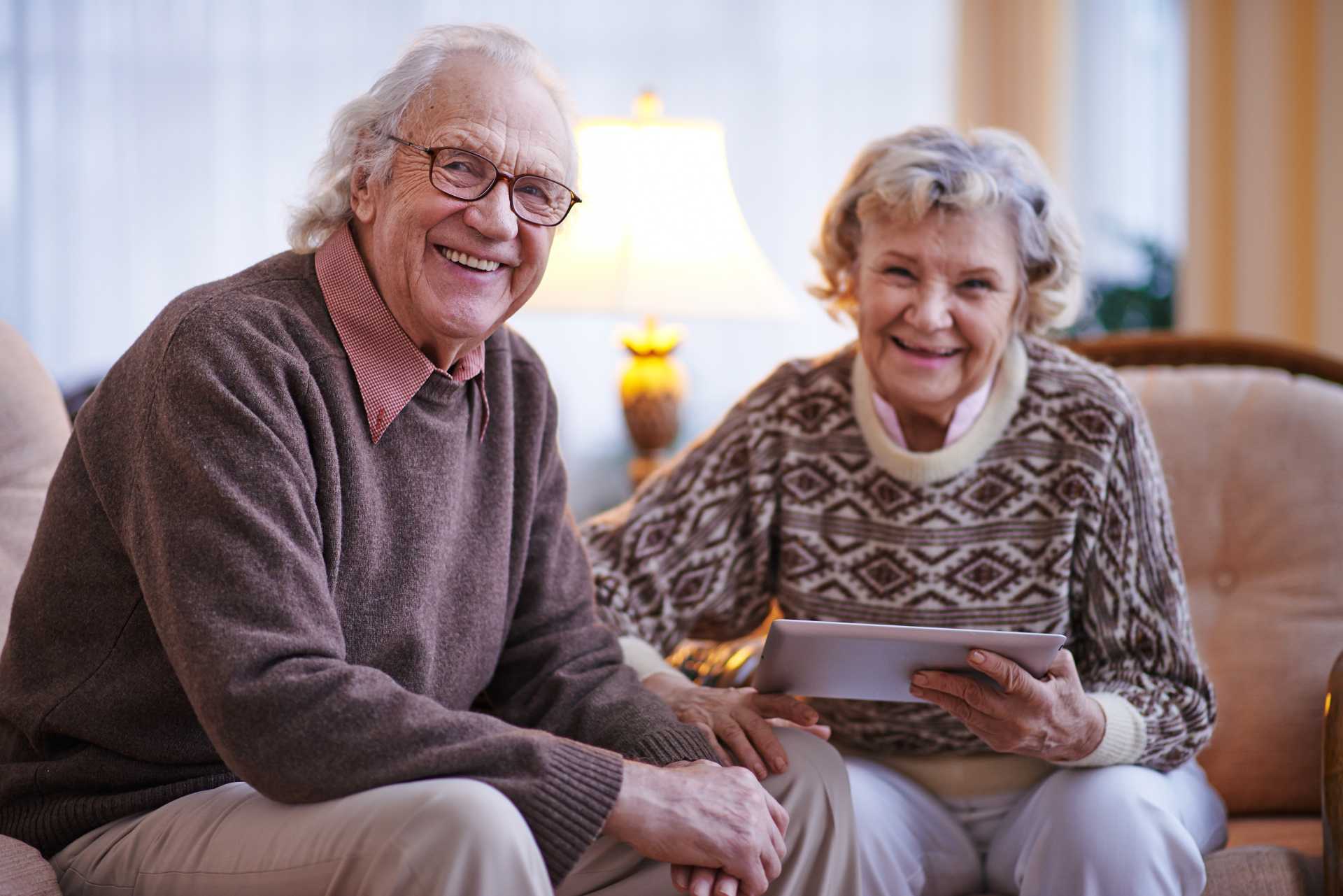 Older couple checking weather updates and staying informed about extreme weather at home.